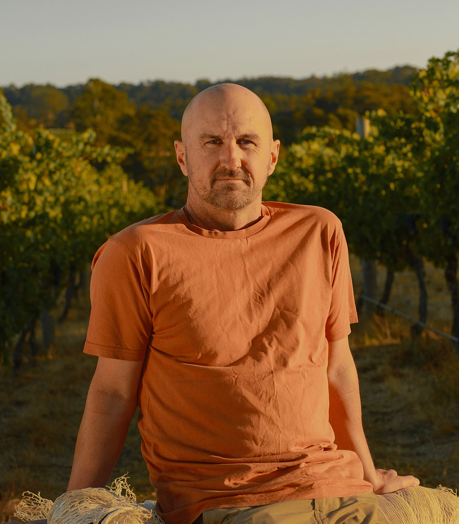Portrait of a Xanadu vineyard team member standing among the vines at sunset